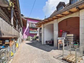 Discover the charm of this unique property, featuring a classic car parked in a covered area.