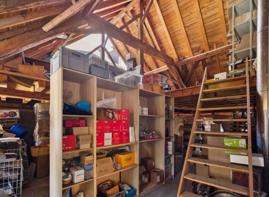 Discover the potential of this unique property! This image showcases a spacious attic with ample storage, perfect for a workshop or extra storage.