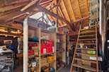 Discover the potential of this unique property! This image showcases a spacious attic with ample storage, perfect for a workshop or extra storage.