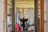 Step into a unique property with this captivating view! This image showcases a glimpse into a rustic interior, highlighting the charm of exposed stone walls and a vintage machine.