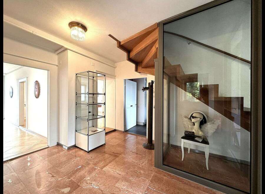 Step into luxury with this stunning property featuring a grand staircase and elegant glass display cases.