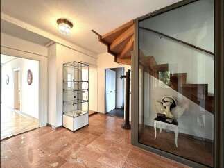 Step into luxury with this stunning property featuring a grand staircase and elegant glass display cases.