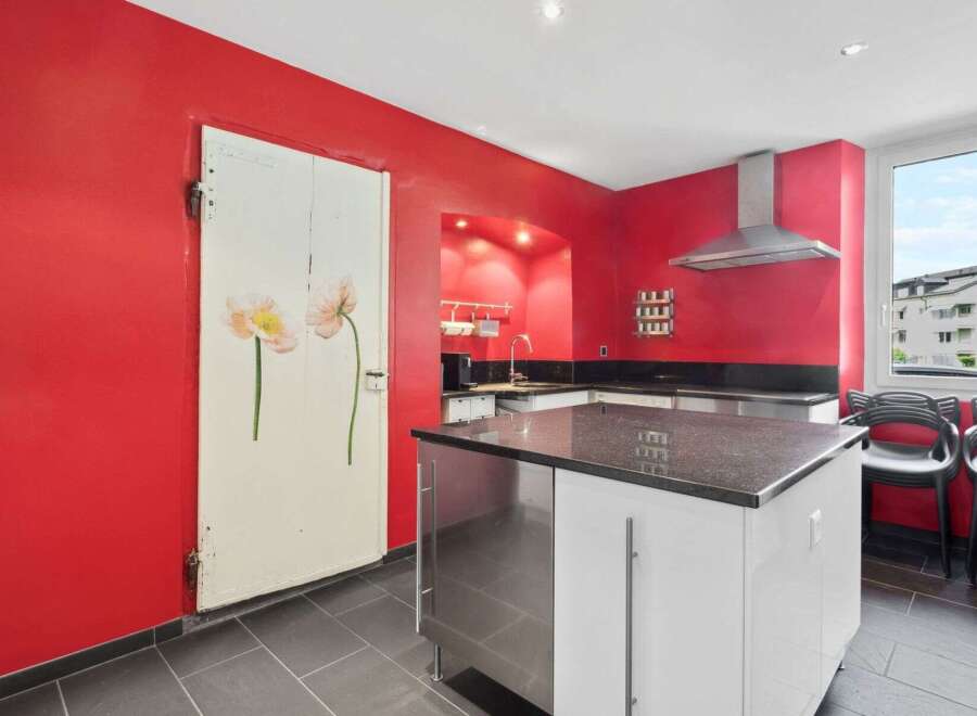 This stunning kitchen boasts a modern design with a striking red color scheme.