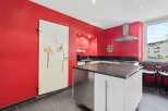This stunning kitchen boasts a modern design with a striking red color scheme.
