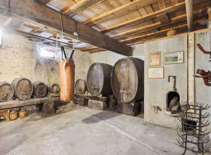Step back in time with this unique property! This image showcases a rustic wine cellar, complete with wooden barrels and a charming, aged aesthetic.