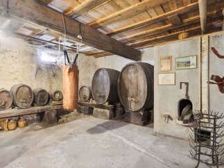 Step back in time with this unique property! This image showcases a rustic wine cellar, complete with wooden barrels and a charming, aged aesthetic.