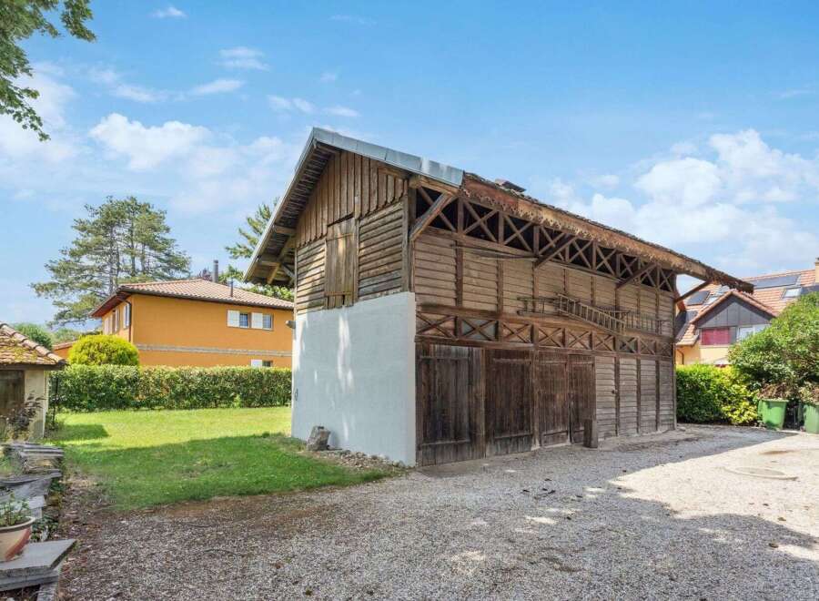 Discover this charming property featuring a rustic wooden barn, perfect for storage or a workshop.
