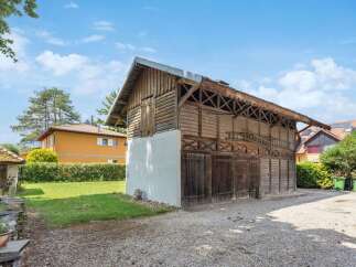 Discover this charming property featuring a rustic wooden barn, perfect for storage or a workshop.