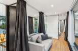Discover modern luxury in this stunning property, featuring a stylish living area with elegant gray curtains and a comfortable sofa.