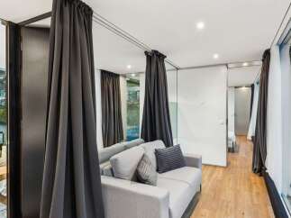 Discover modern luxury in this stunning property, featuring a stylish living area with elegant gray curtains and a comfortable sofa.