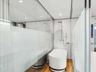 Experience luxury in this modern bathroom featuring a sleek, freestanding bathtub and a separate shower area.