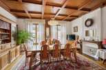 Step into luxury with this stunning dining room, featuring a beautiful wooden ceiling and elegant chandelier.