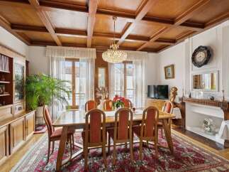Step into luxury with this stunning dining room, featuring a beautiful wooden ceiling and elegant chandelier.