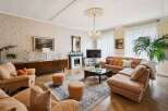 Step into luxury with this stunning living room, featuring a cozy seating area and a beautiful fireplace.