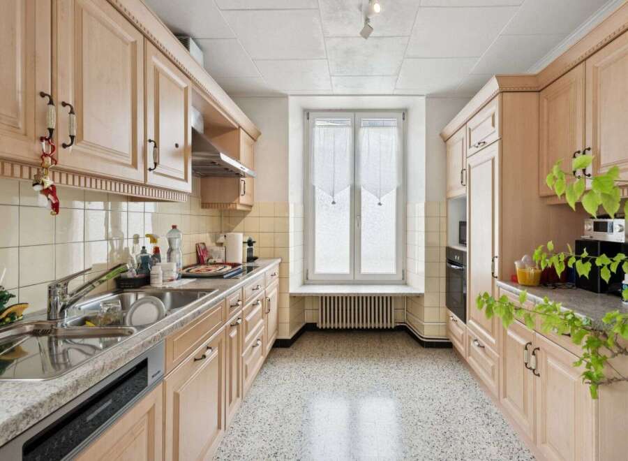 This charming kitchen boasts ample storage with its light wood cabinetry, offering a warm and inviting atmosphere.