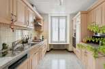 This charming kitchen boasts ample storage with its light wood cabinetry, offering a warm and inviting atmosphere.
