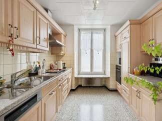 This charming kitchen boasts ample storage with its light wood cabinetry, offering a warm and inviting atmosphere.