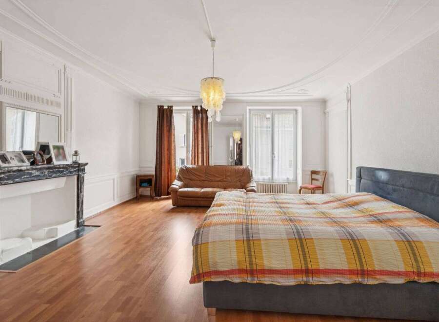 Discover the charm of this elegant bedroom, featuring a cozy bed adorned with a vibrant plaid blanket.