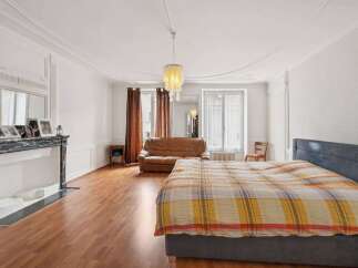 Discover the charm of this elegant bedroom, featuring a cozy bed adorned with a vibrant plaid blanket.