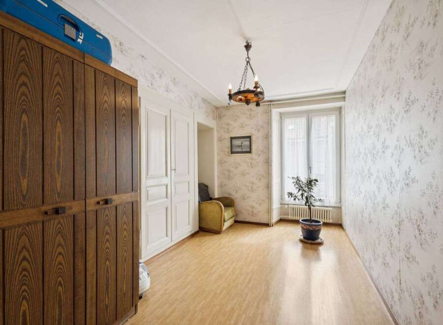 Discover the charm of this inviting room, featuring a beautiful wooden wardrobe and elegant white doors.