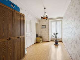 Discover the charm of this inviting room, featuring a beautiful wooden wardrobe and elegant white doors.