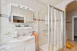This bright and airy bathroom features a modern shower enclosure and a stylish vanity with ample storage.