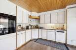 This charming kitchen boasts a warm, inviting atmosphere with its wooden ceiling and ample natural light.