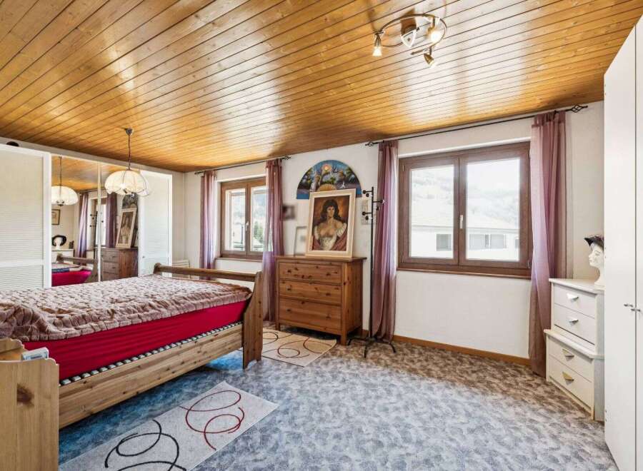 Discover the charm of this inviting bedroom, featuring a warm wooden ceiling and a cozy ambiance.