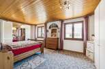 Discover the charm of this inviting bedroom, featuring a warm wooden ceiling and a cozy ambiance.