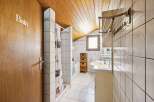 Step into this charming bathroom, featuring a unique sloped ceiling and a cozy atmosphere.
