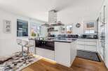 This stunning kitchen boasts a modern design with sleek white cabinetry and a contrasting dark countertop, creating a sophisticated and inviting atmosphere.
