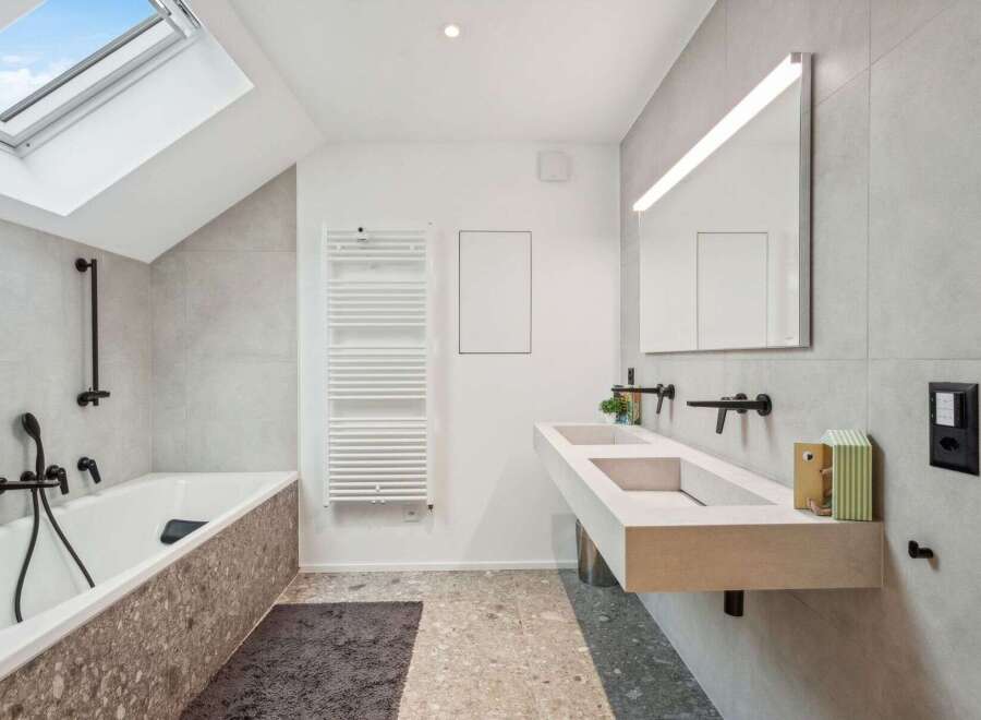 Step into a modern bathroom oasis! This stunning space features a sleek, minimalist design with a double sink vanity and a luxurious soaking tub.