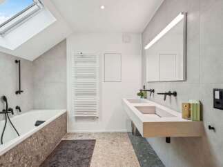 Step into a modern bathroom oasis! This stunning space features a sleek, minimalist design with a double sink vanity and a luxurious soaking tub.