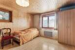 Cozy bedroom with wooden paneling and a comfortable bed.