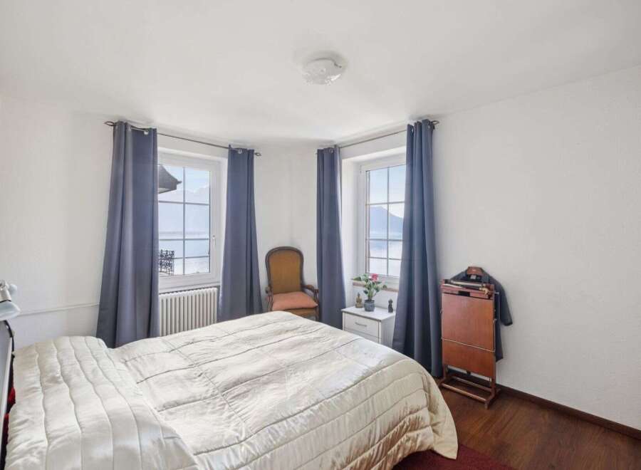 Experience serene living in this charming bedroom, featuring stunning views from its windows.
