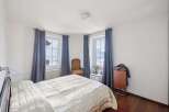 Experience serene living in this charming bedroom, featuring stunning views from its windows.