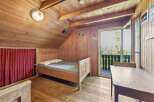 This charming cabin bedroom offers a cozy retreat with its wooden interior and natural light.