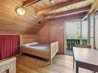 This charming cabin bedroom offers a cozy retreat with its wooden interior and natural light.