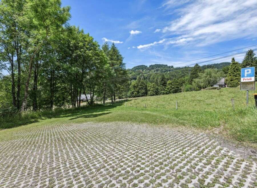 Discover this stunning property featuring a unique parking area with a grass-filled grid, blending seamlessly with the natural landscape.
