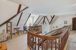 Step into luxury with this stunning property featuring a grand staircase and elegant wooden accents.