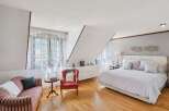 This stunning bedroom boasts a unique architectural design with a slanted ceiling, creating a modern and airy feel.