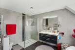 Step into this modern bathroom, featuring a sleek shower enclosure and stylish vanity.