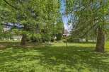 Discover the tranquility of this stunning property, featuring a lush, expansive lawn perfect for outdoor activities.