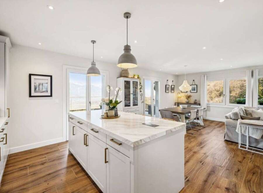 This stunning kitchen boasts a spacious island with elegant marble countertops, perfect for meal preparation and entertaining.