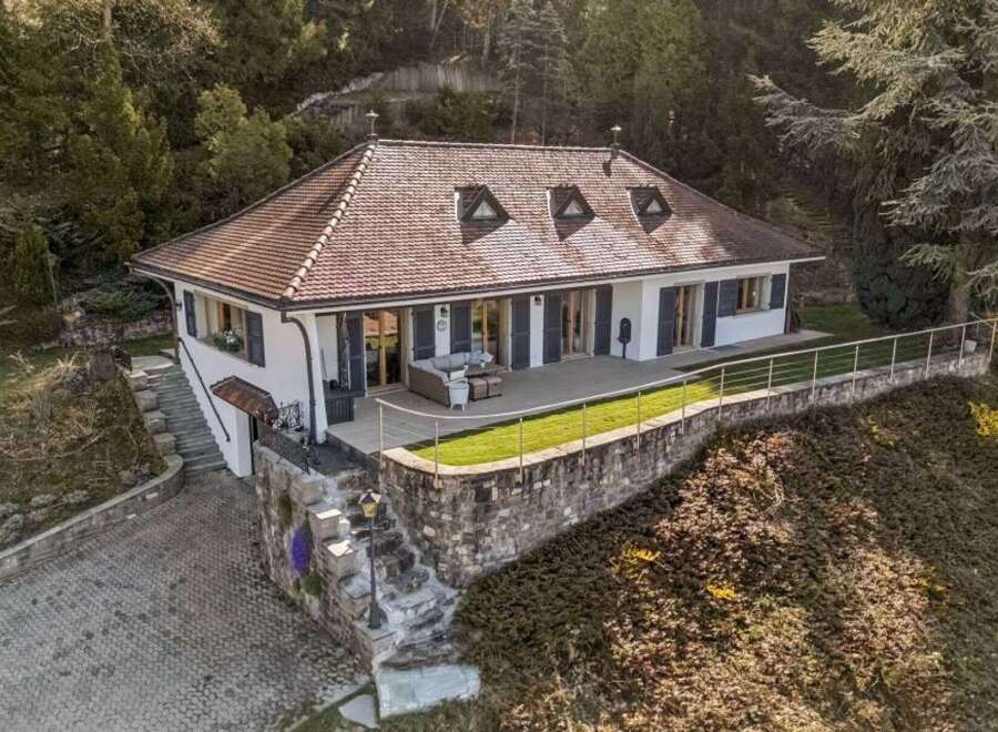 Discover this stunning property featuring a beautifully designed house with a charming red-tiled roof and elegant white exterior.