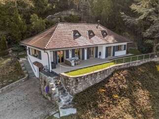 Discover this stunning property featuring a beautifully designed house with a charming red-tiled roof and elegant white exterior.