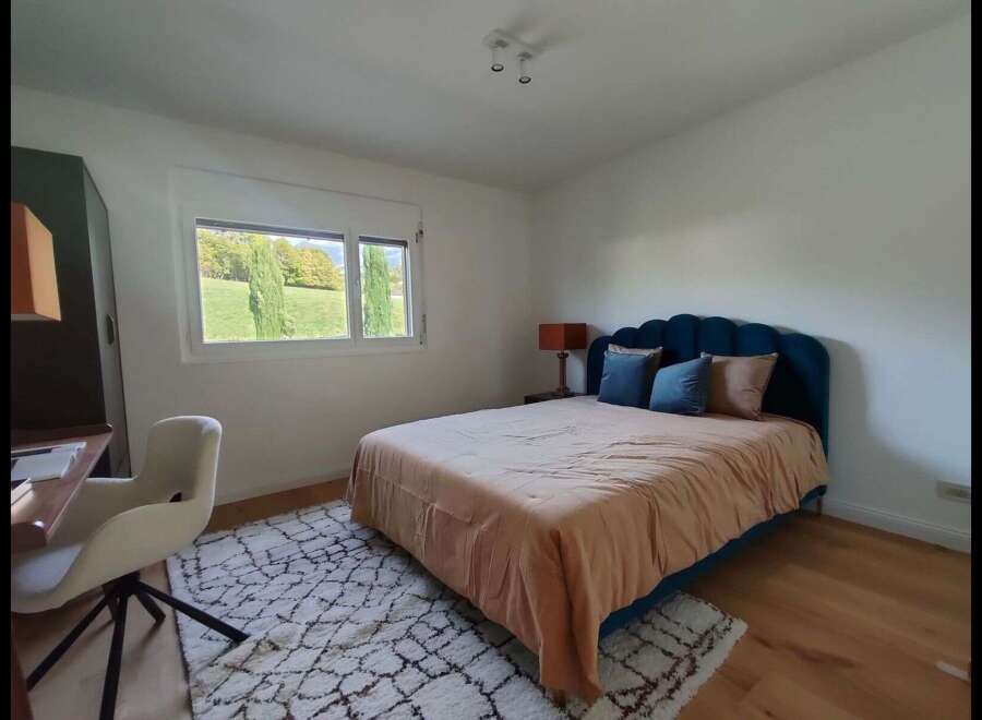 This charming bedroom features a stylish bed with a unique headboard, creating a cozy and inviting atmosphere.