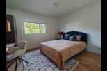This charming bedroom features a stylish bed with a unique headboard, creating a cozy and inviting atmosphere.