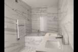 This luxurious bathroom boasts a modern design with stunning marble-like tiles, creating a spa-like ambiance.