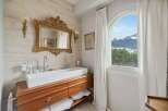 Experience luxury in this exquisite bathroom featuring a stunning gold-framed mirror and a sleek, modern sink.